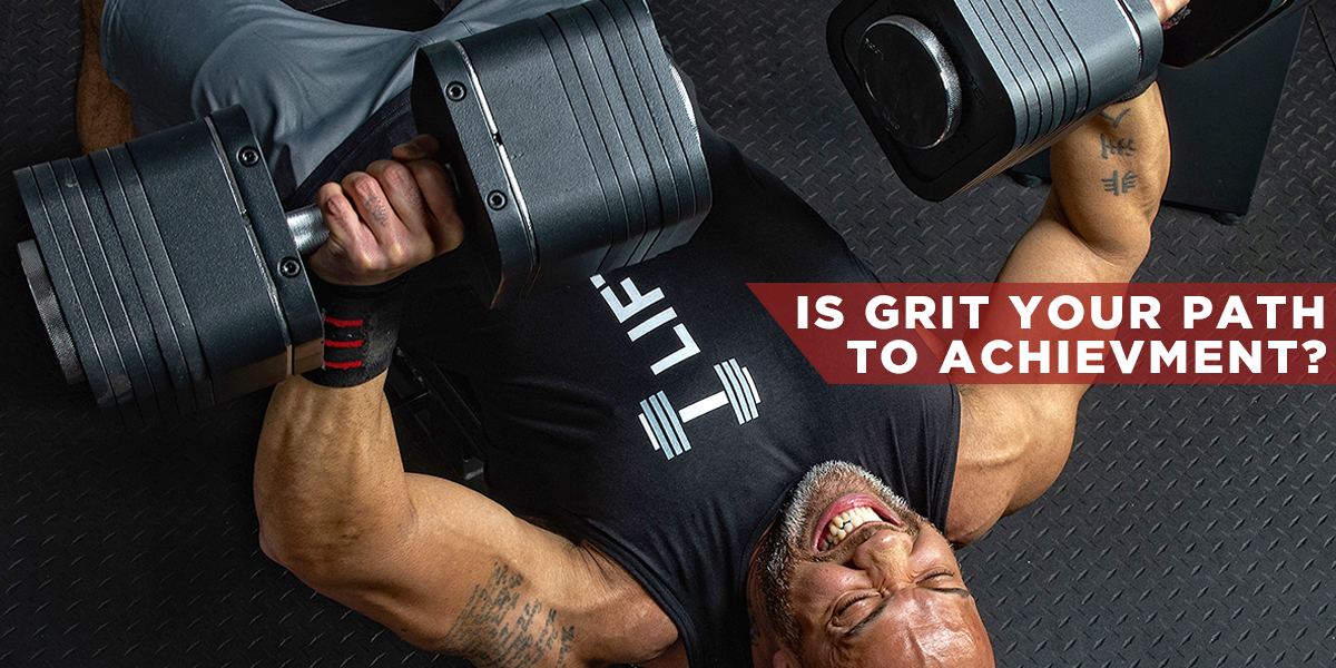 Image: man exherting great strength to bench press heavy dumbbells. Ironmaster.com Iron Blog Article: Is Grit Your Path to Achievement?